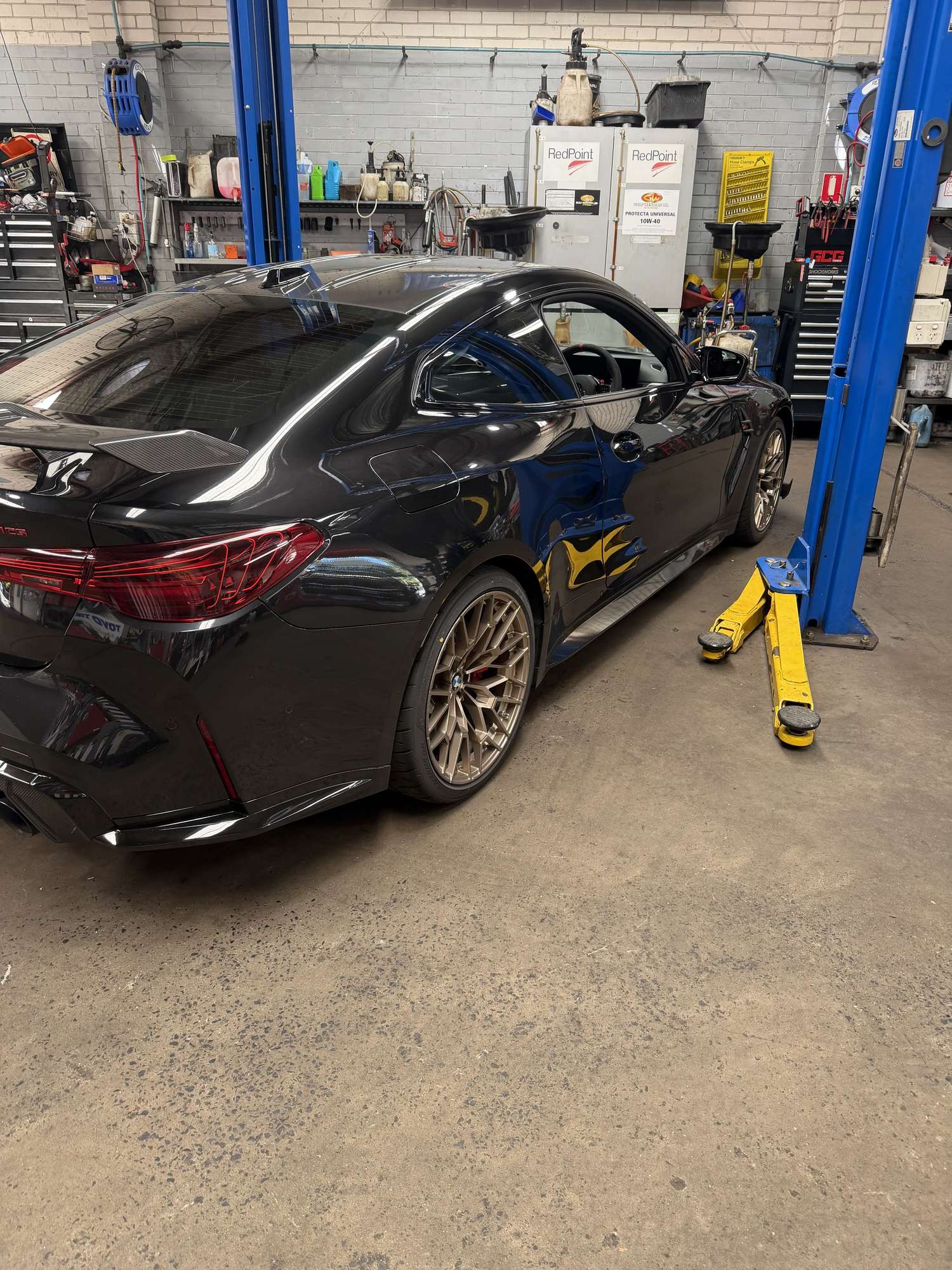 BMW coupe on a hoist inside the Hornsby Car Care workshop